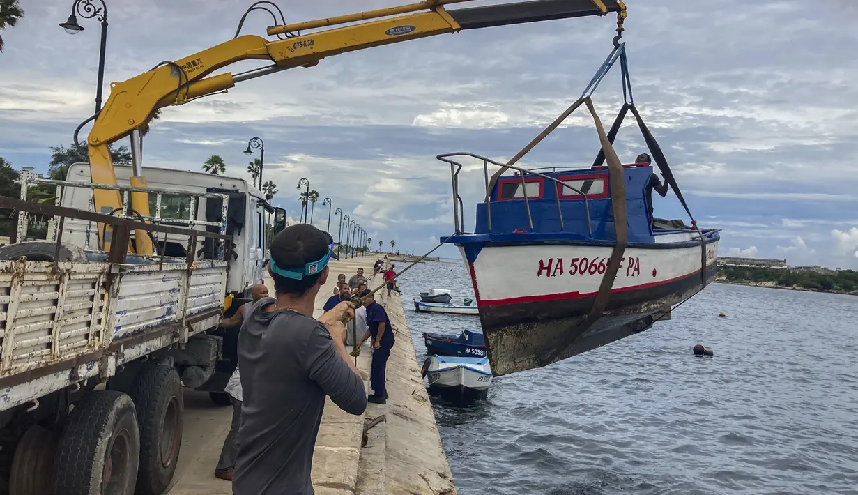 Pekerja memindahkan perahu dari air di teluk Havana, Kuba, Senin, 26 September 2022. Badai Ian semakin kuat saat mendekati ujung barat Kuba di jalur untuk menghantam pantai barat Florida sebagai badai besar paling cepat pada hari Rabu. (Foto AP/Milexsy Duran)