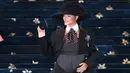 Rihanna tampil sambil memamerkan kehamilannya yang dibalut korset abu-abu dikombinasikan rok hitam selutut dan jaket hitam pendek—semuanya dari Marc Jacobs, yang juga mendesain sepatu hak, dasi, dan topinya (dengan pembuat topi Stephen Jones). (Andrea RENAULT/AFP)