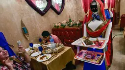 Pengunjung mengambil gambar pelayan robot bernama Ruby yang sedang mengantar makanan kepada pelanggan di restoran Drink and Spice Magic, Dubai, 26 Juli 2018. Robot Jepang itu bekerja tanpa henti dari jam 7 pagi hingga jam 2 pagi. (AFP/GIUSEPPE CACACE)