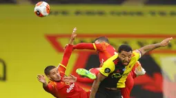 Striker Watford, Troy Deeney, berebut bola dengan pemain Norwich City pada laga lanjutan ke-34 di Stadion Vicarage Road, Rabu (8/7/2020) dini hari WIB. Watford menang 2-1 atas Norwich City. (AFP/Richard Heathcote/various sources)