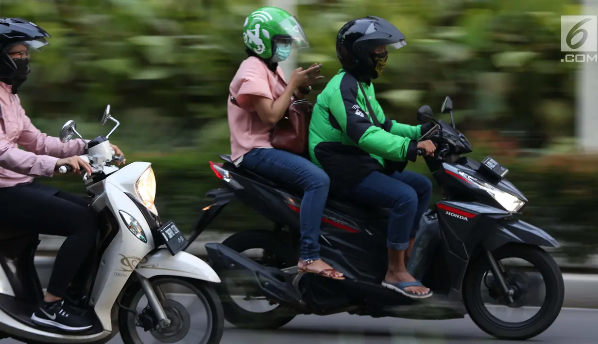 Pengemudi ojek online melintasi Jalan Pintu I Senayan, Jakarta, Selasa (19/3). Kemenhub mengeluarkan Permen No.12 tahun 2019 tentang perlindungan keselamatan pengguna motor yang digunakan untuk kepentingan masyarakat. (Liputan6.com/Helmi Fithriansyah)