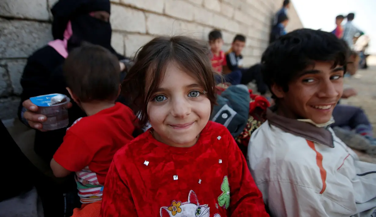 Seorang gadis Irak tersenyum setelah melarikan diri dari desa yang dikuasai ISIS, Irak, Senin (31/10). (REUTERS / Azad Lashkari )