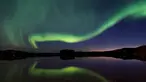 Cahaya aurora borealis menerangi langit malam Desa Erikslund di Vasternorrland County, Swedia (23/8). Fenomena alam yang indah ini terjadi pada bulan Maret-April dan September-Oktober. (AFP PHOTO/ JONATHAN NACKSTRAND)