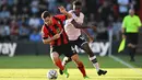 Pemain Bournemouth Lewis Cook (depan) berebut bola dengan pemain Arsenal Eddie Nketiah (belakang) pada pertandingan sepak bola Liga Premier Inggris di Stadion Vitality, Bournemouth, Inggris, 20 Agustus 2022. Arsenal menang 3-0. (Glyn KIRK/AFP)