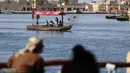 Orang Emirat terlihat sebagai perahu yang membawa turis berlayar di suaka margasatwa Ras Al-Khor dekat kawasan tua kota Teluk Dubai (6/1/2021).  (AFP/Karim Sahib)