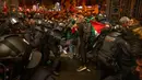 Dalam aksi itu, massa mengibarkan bendera Palestina sebagai bentuk dukungan untuk warga Palestina yang sedang dibombardir Israel. (AP Photo/Emilio Morenatti)