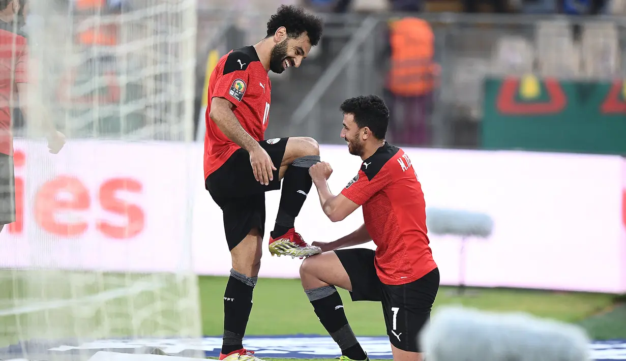 Gelandang Mesir Mahmoud 'Trezeguet' Hassan (kanan) berselebrasi dengan Mohamed Salah setelah mencetak gol pada menit ke-100 ke gawang Maroko pada pertandingan perempat final Piala Afrika (CAN) 2021 di Stade Ahmadou Ahidjo di Yaounde (30/1/2022). Mesir menang atas Maroko 2-1. (AFP/Charly Triballeau)
