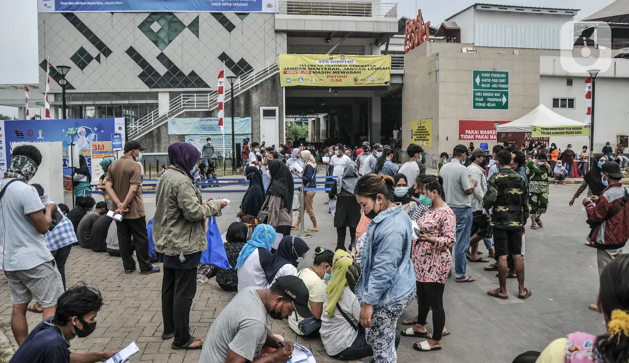 Warga antre mendaftar untuk mengikuti vaksinasi massal Covid-19 di Pasar Ikan Modern Muara Baru, Penjaringan, Jakarta, Kamis (5/8/2021). Vaksinasi massal di Pasar Ikan Muara Baru pada 5-7 Agustus ini menyasar masyarakat kawasan pesisir yang berusia 12 tahun ke atas. (merdeka.com/Iqbal S Nugroho)