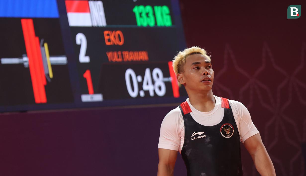 <p>Atlet angkat besi Indonesia, Eko Yuli Irawan berkompetisi pada nomor angkat besi putra 61 kg SEA Games 2023 di Taekwondo Hall Olympic Complex, Phnom Penh, Kamboja, Sabtu (13/05/2023). (Bola.com/Abdul Aziz)</p>