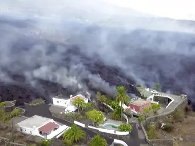Gambar dari video lava terlihat setelah letusan gunung berapi di La Palma, Spanyol (20/9/2021). Lava raksasa berjatuhan perlahan tapi tanpa henti ke arah laut setelah gunung berapi meletus di Spanyol. (OVERON via AP)
