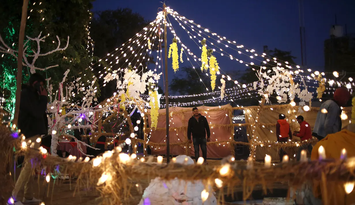 Umat Kristen mengunjungi kandang yang didekorasi khusus untuk perayaan Natal, di lingkungan Kristen Islamabad, Pakistan, Jumat (24/12/2021). (AP Photo/Anjum Naveed)