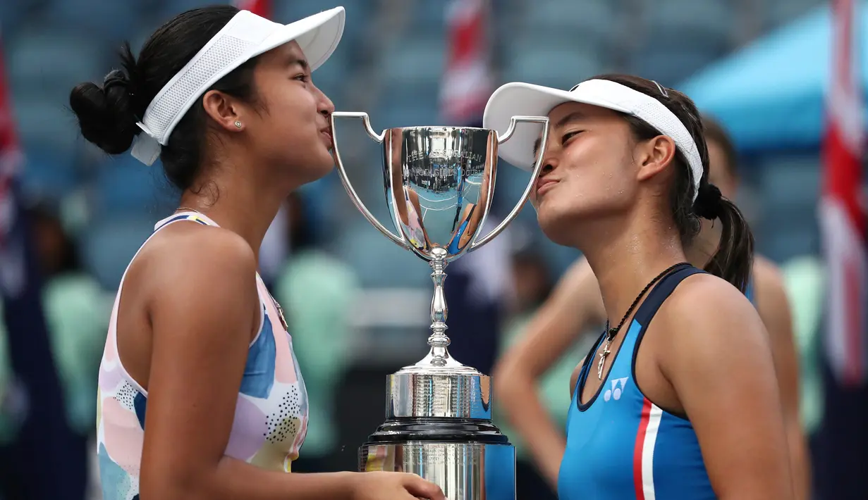 Alexandra Eala dari Filipina (kiri) dan Priska Madelyn Nugroho dari Indonesia berpose dengan piala usai mengalahkan Ziva Falkner (Slovenia)/Matilda Mutavdzic (Inggris) pada final Australia Terbuka Junior 2020 di Melbourne, Jumat (31/1/2020). Priska/Alexandra menang 6-1, 6-2. (AP/Dita Alangkara)