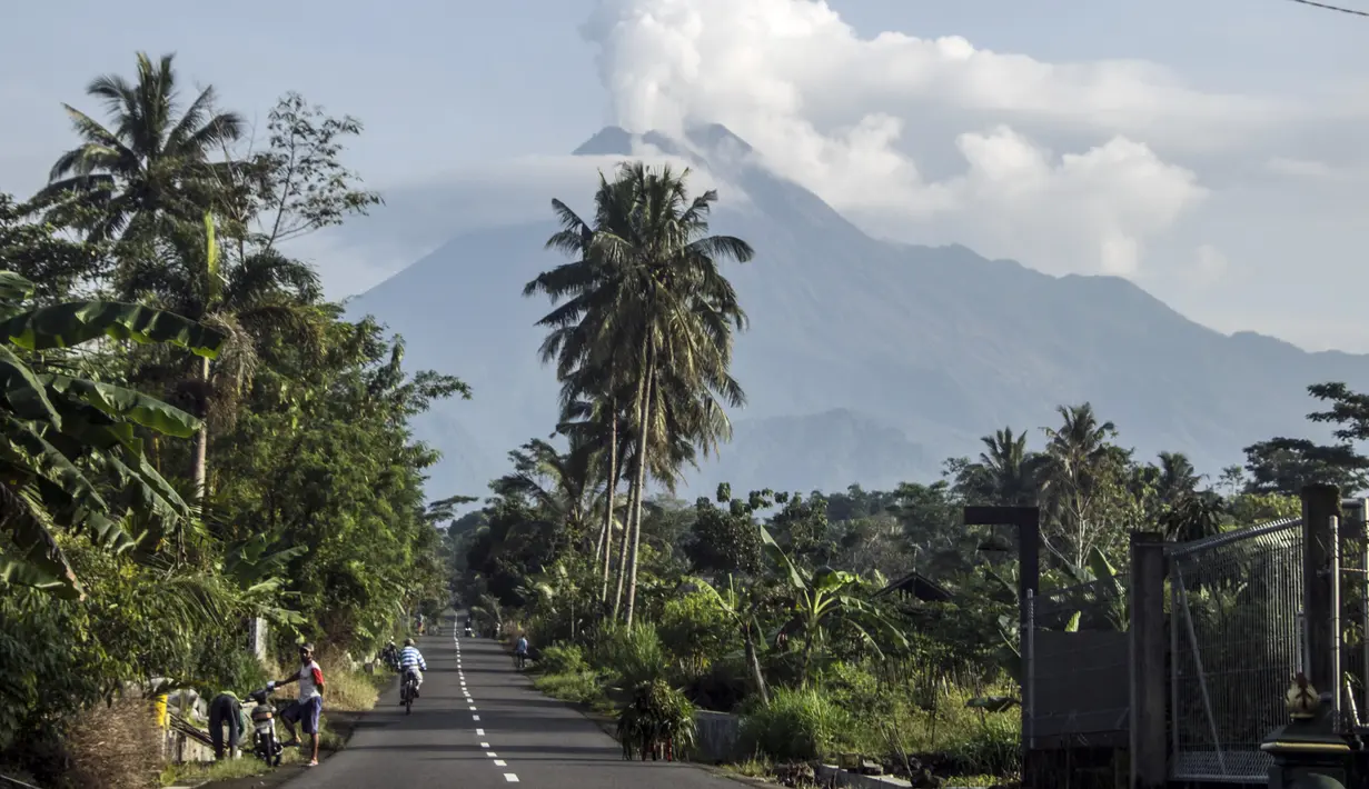 <p>Aktivitas warga saat Gunung Merapi memuntahkan material vulkanik dari kawahnya di Sleman, Yogyakarta (7/1/2021). Kondisi cuaca disekitar gunung terpantau cerah hingga hujan, angin lemah hingga sedang ke arah timur, barat daya dan barat. (AP Photo/Slamet Riyadi)</p>