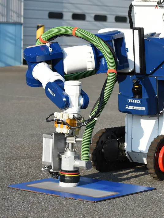 Sebuah unit robot dikendalikan dari jarak jauh untuk menghilangkan serbuk besi akibat ledakan nuklir saat demonstrasi di Chiba, Jepang (16/12). Robot dikembangkan untuk pembangkit nuklir Fukushima yang mengalami krisis sejak Tsunami. (AFP/Toru Yamanaka)