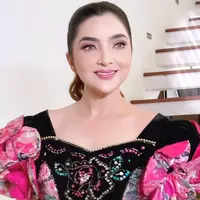 Gaun tersebut didominasi warna hitam dengan hiasan motif bunga berkilauan, dipadukan dengan aksen warna pink cerah yang memberikan kesan glamor dan anggun. [@ashanty_ash].