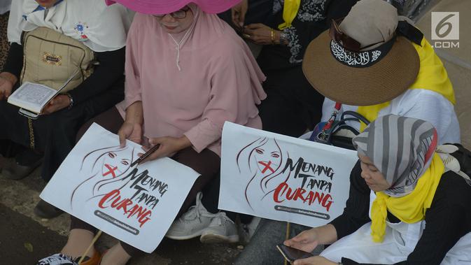 Massa aksi membawa poster untuk menggelar aksi kawal putusan hasil sengketa pilpres 2019 di sekitar Gedung Mahkamah Konstitusi (MK), Jakarta, Kamis (27/6/2019). Para demonstran yang turun ke jalan hanya duduk di sekitaran kawasan Patung Kuda yang telah ditutup oleh petugas. (merdeka.com/Imam Buhori)