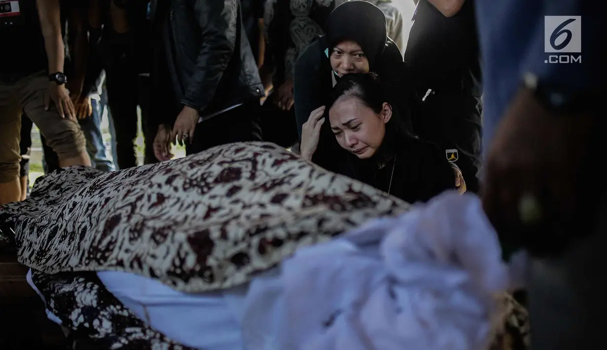 Kekasih almarhum Andika Putra Sahadewa, Nicky Santoso menangis di dekat makam di TPU Sunan Giri, Rawamangun, Jakarta, Selasa (10/9). Bassist grup band Kerispatih, Andika Putra Sahadewa, meninggal dunia di usia 36 tahun. (Liputan6.com/Faizal Fanani)