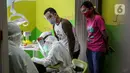 Dokter menggunakan APD memeriksa gigi pasien anak di klinik Medikids kawasan Kemang, Jakarta Selatan, Selasa (7/7/2020). Pelayanan dokter gigi dengan menggunakan APD lengkap  untuk memenuhi protokol kesehatan guna mencegah penyebaran covid-19 di era kenormalan baru. (Liputan6.com/Faizal Fanani)