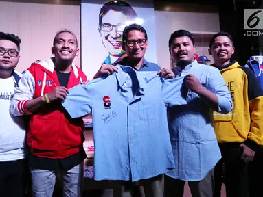 Cawapres nomor urut 02, Sandiaga Uno menunjukkan baju yang telah ditandatangani pada peluncuran merek merchandise Thesandiuno, di Jakarta, Senin (04/2). Merchandise Thesandiuno didesain menyasar pangsa pasar milenial. (Liputan6.com/Fery Pradolo)