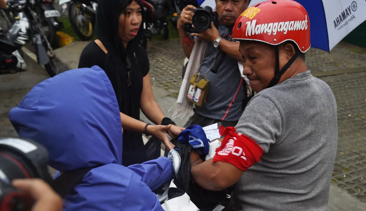 Seorang pendukung diktator Filipina Ferdinand Marcos mencoba mengambil sebuah spanduk dari seorang demonstran saat menggelar aksi saat perayaan ulang tahun ke-100 di Manila (11/9). (AFP Photo/Ted Aljibe)