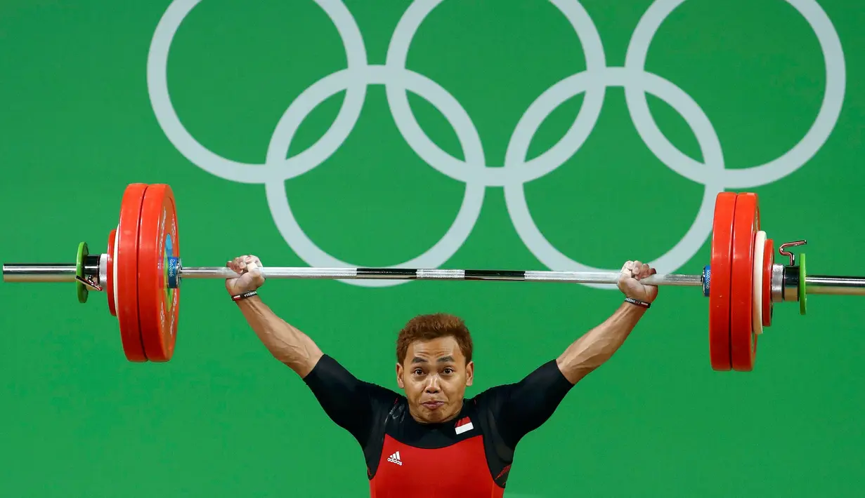 Lifter Indonesia, Eko Yuli Irawan mengangkat beban selama kompetisi cabang olahraga angkat besi 62 KG di Olimpiade 2016, Senin (8/8). Eko Yuli mencatatkan total angkatan 312 KG dari snatch 142KG dan clean & jerk 170 KG. (REUTERS/Yves Herman)