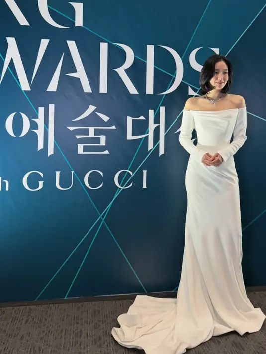 Kim Go Eun mengenakan long dress putih off shoulder lengan panjang dari Leah da Gloria dipadukan kalung silvernya. [@ggonekim]