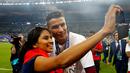 Cristiano Ronaldo berfoto dengan seorang fan seusai menjuarai Piala Eropa 2016 di Stade de France, Saint-Denis, Senin (11/7/2016) dini hari WIB. (Reuters/Michael Dalder)