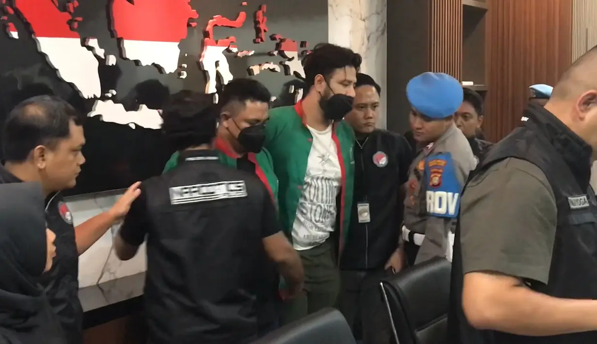 Kali ini, Ammar mengenakan baju tahanan warna hijau no 03 dengan garis merah. Sedangkan kaos dalam yang dikenakan masih sama dengan saat menjalani pemeriksaan pada Kamis (14/12). [Foto: KapanLagi.com/Dadan Eka Purnama]