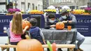 Warga New York mengukir labu dalam persiapan Halloween di Rockefeller Center (22/10/2020). Para pekerja di Rockefeller Center beristirahat sejenak untuk mempelajari cara mengukir labu dengan benar dari Maniac Pumpkin Carvers, seniman dari Brooklyn . (Diane Bondareff/AP Images for Tishman Speyer)