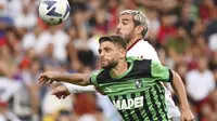 Bek AC Milan, Theo Hernandez berebut bola dengan penyerang Sassuolo, Domenico Berardi pada pertandingan lanjutan Liga Serie A Italia di stadion Mapei - Citta del Tricolore di Reggio Emilia (30/8/2022). AC Milan bermain imbang atas Sassuolo dengan skor 0-0. (Massimo Paolone / LaPresse via AP)