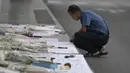 Seorang pria menulis pesan untuk korban penembakan massal di mal Terminal 21 Korat di Nakhon Ratchasima, Thailand, Senin, (10/2/2020). Sebanyak 26 orang tewas dan melukai puluhan lainnya akibat insiden tersebut. (AP Photo/Sakchai Lalit)