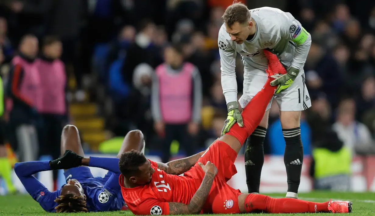 Kiper Bayern Munchen Manuel Neuer (kanan) membantu meregangkan kaki Jerome Boateng pada pertandingan babak 16 besar Liga Champions di Stamford Brige Stadium, London, Inggris, Selasa (25/2/2020). Bayern Munchen menang dengan skor 3-0. (AP Photo/Kirsty Wigglesworth)