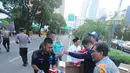 Koordinator Nasional Relawan GOJO (Golkar Jokowi) Rizal Malarangeng (batik) memberikan makanan berbuka kepada para aparat yang melakukan penjagaan gedung KPU, Menteng, Jakarta Pusat, Kamis (23/5/). (Liputan6.com/Angga Yuniar)
