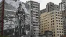 Mural berjudul "The Forest Brigadir" menggunakan abu kebakaran hutan Amazon oleh seniman Thiago Mundano, menutupi kompleks apartemen di Sao Paulo, Brasil, Jumat (15/10/2021). Mural bergambar petugas damkar yang berdiri di tengah peristiwa deforestasi, kebakaran, dan hewan mati. (AP/Marcelo Chello)