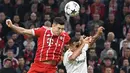 Pemain Bayern Munchen Robert Lewandowski berebut bola dengan pemain Sevilla Gabriel Ivan Mercado pada laga leg kedua perempat final Liga Champions di Allianz Arena, Kamis (12/4). Bayern Munchen lolos ke semifinal dengan agregat 2-1. (AP/Matthias Schrader)