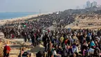 Orang-orang berjalan di sepanjang Jalan Al-Rashid di wilayah pesisir untuk menyeberangi koridor Netzarim dari Jalur Gaza selatan ke utara pada 27 Januari 2025. (Omar AL-QATTAA/AFP)