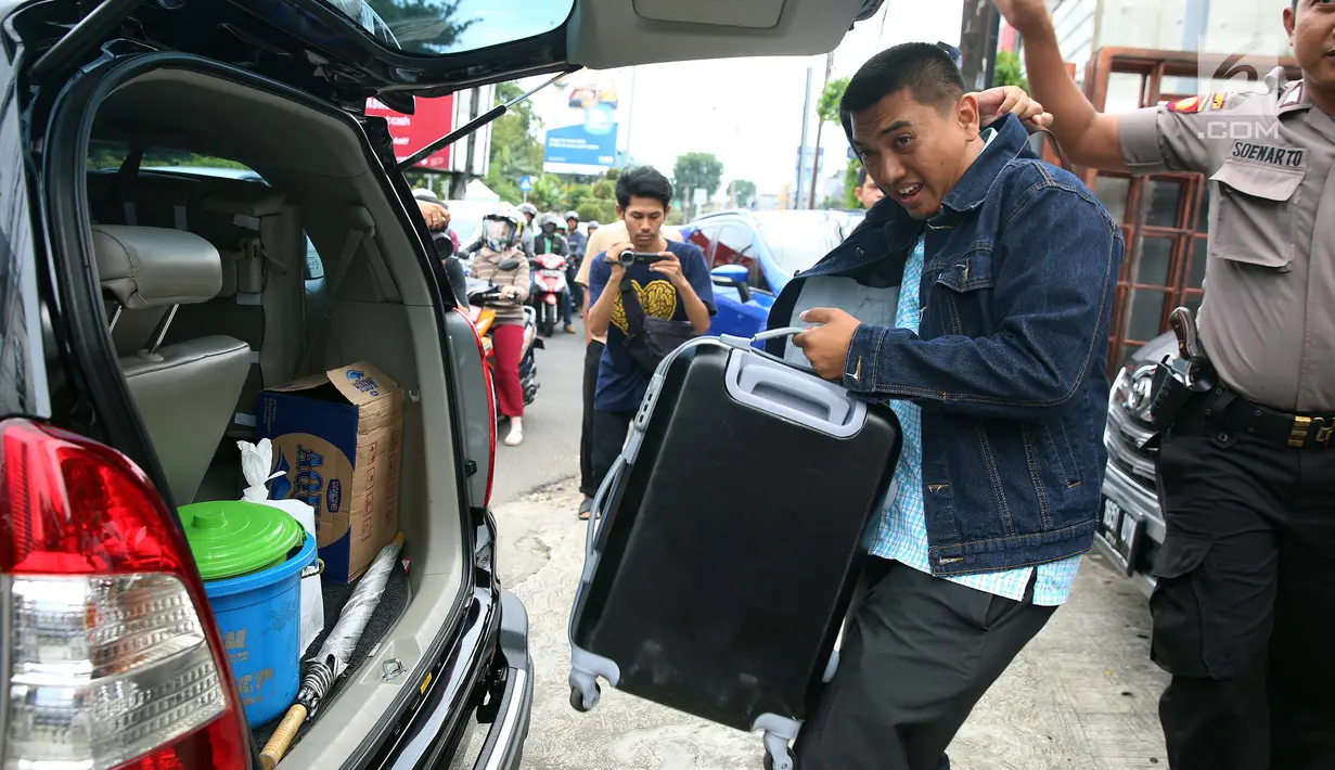 Penyidik KPK memasukkan koper berisi dokumen ke dalam mobil usai menggeledah kantor mantan kuasa hukum Setya Novanto, Fredrich Yunadi, di Jakarta, Kamis (11/1). Sebanyak empat mobil membawa para penyidik dan barang bukti. (Liputan6.com/Johan Tallo)