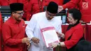 Ketua Umum PDIP Megawati Soekarno Putri (kanan) menyerahkan surat rekomendasi pada Pasangan Cagub-Cawagub Jawa Timur, Saifullah Yusuf (baju putih) dan Abdullah Azwar Anas usai ditetapkan di Jakarta, Minggu (15/10). (Liputan6.com/Helmi Fithriansyah)