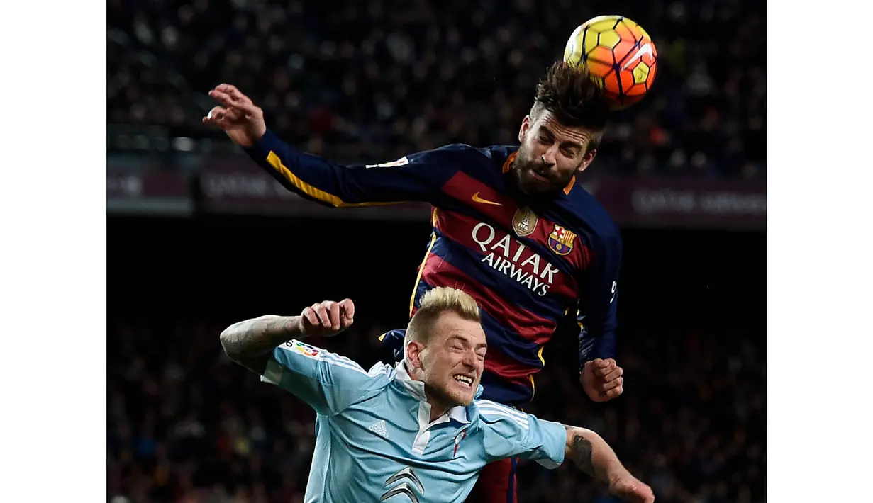 Pemain Celta Vigo, John Guidetti (bawah) berduel dengan Pemain Barcelona Gerard Pique   pada lanjutan La Liga Spanyol di Stadion Camp Nou, Barceloa, Senin (15/2/2016) dini hari WIB. Barcelona menang 6-1. (AFP/Josep Lago)