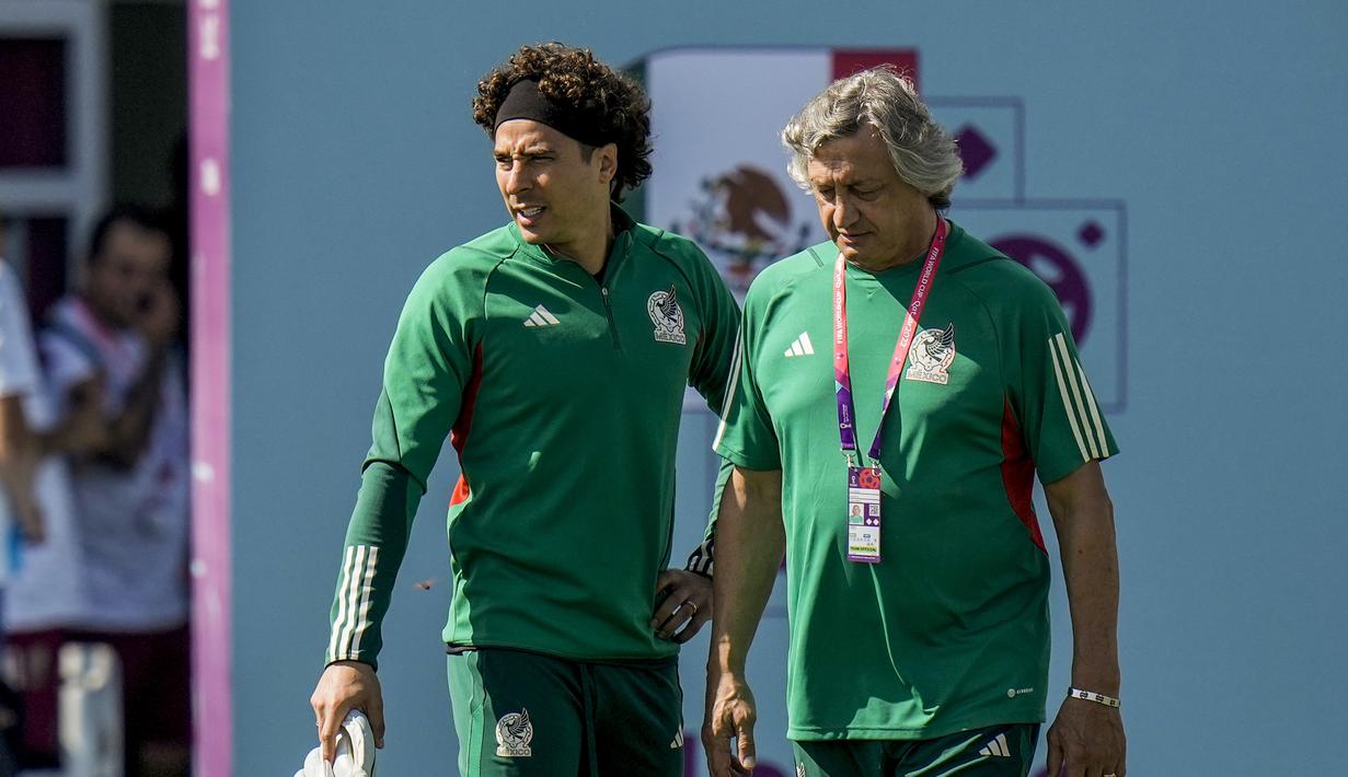 Kiper Meksiko, Guillermo Ochoa (kiri) dan asisten pelatih Norberto Scoponi berbicara selama latihan tim di Jor, Qatar, Selasa, 29 November 2022. Saat ini, baik Arab Saudi maupun Meksiko masih memiliki peluang untuk lolos ke babak 16 besar. Kedua tim harus saling mengalahkan untuk mengamankan laju mereka di Piala Dunia 2022. (AP Photo/Moises Castillo)