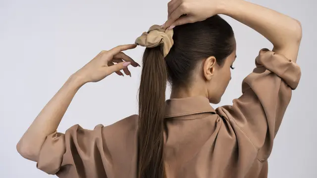 Seorang perempuan sedang mengikat rambut panjangnya (Foto Dok: Freepik/freepik)