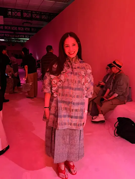 Nagita Slavina hadir dengan tunik top dan midi skirt dari SAPTO DJOJOKARTIKO Spring/Summer 2027. Dipadukan dengan orange mesh sandals yang memberikan pernyataan gaya untuk keseluruhan look. / Foto dok: Fimela.com.
