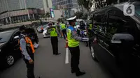 Petugas gabungan dari Polisi, Dishub, dan Satpol PP mengimbau pengguna kendaraan saat melakukan Pengawasan Pelaksanaan PSBB di Bundaran HI, Jakarta, Senin (13/4/2020). Dalam pengawasan tersebut petugas mengimbau masyarakat untuk menggunakan masker saat berpergian. (Liputan6.com/Faizal Fanani)