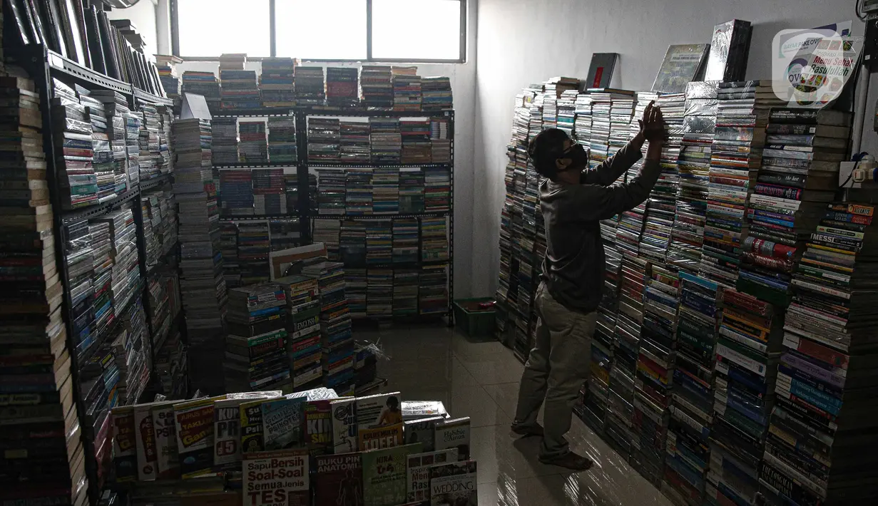 Pedagang merapikan buku bacaan di Pasar Kenari, Jakarta, Rabu (24/11/2021). Pasar Buku Kenari sangat sepi dari pengunjung di saat masa pandemi Covid-19 sekarang ini. (Liputan6.com/Faizal Fanani)