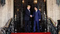 Presiden AS, Donald Trump menyambut kedatangan PM Jepang Shinzo Abe dalam pertemuan mereka di Resor Mar-a-Lago, Florida, Selasa (17/4). Pertemuan digunakan untuk mencari pemahaman bersama mengenai masalah nuklir Korea Utara. (AP/Pablo Martinez Monsivais)