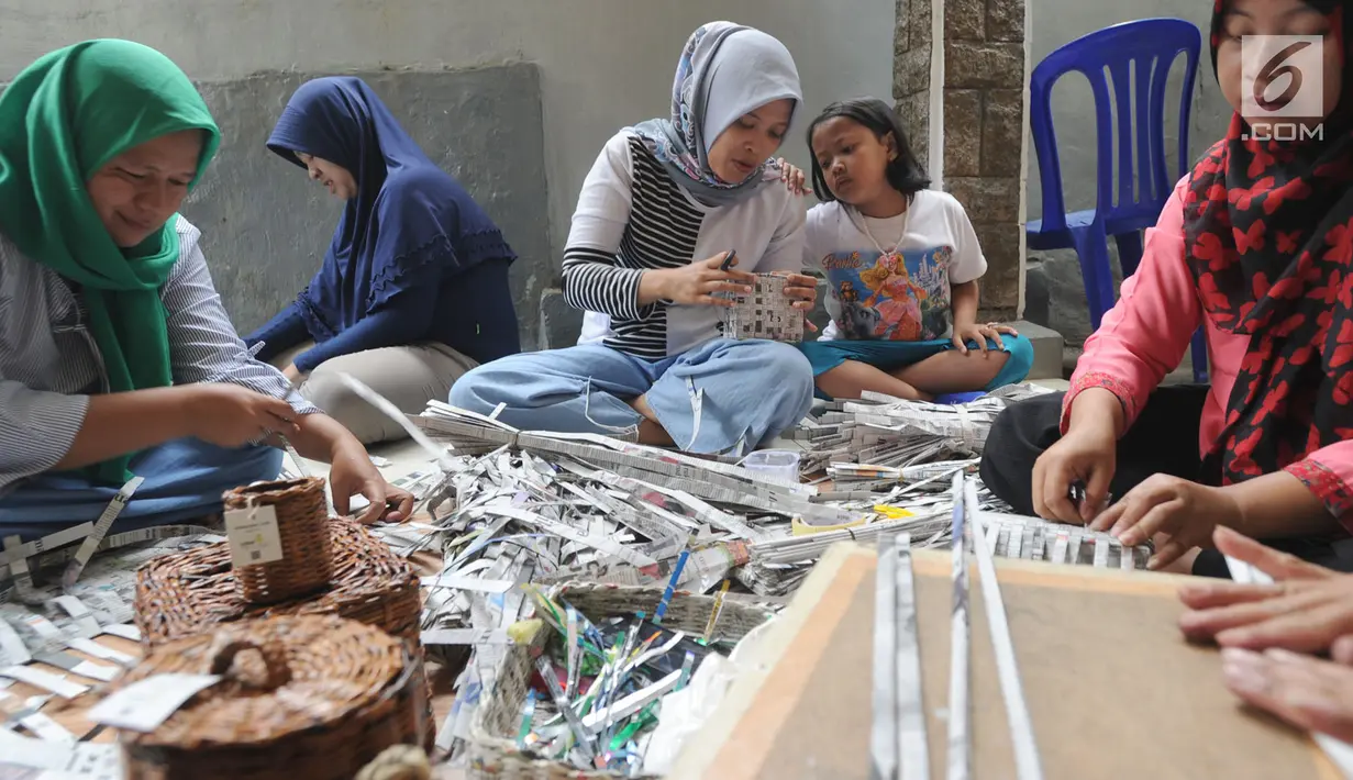 Sejumlah ibu membuat kerajinan tangan dari koran bekas di Kampung Sirnasari, Tanah Baru, Bogor, Rabu (13/2). Industri rumahan tersebut mampu menyumbangkan pendapatan hingga Rp 1,5 juta/bulan bagi setiap keluarga. (Merdeka.com/Arie Basuki)