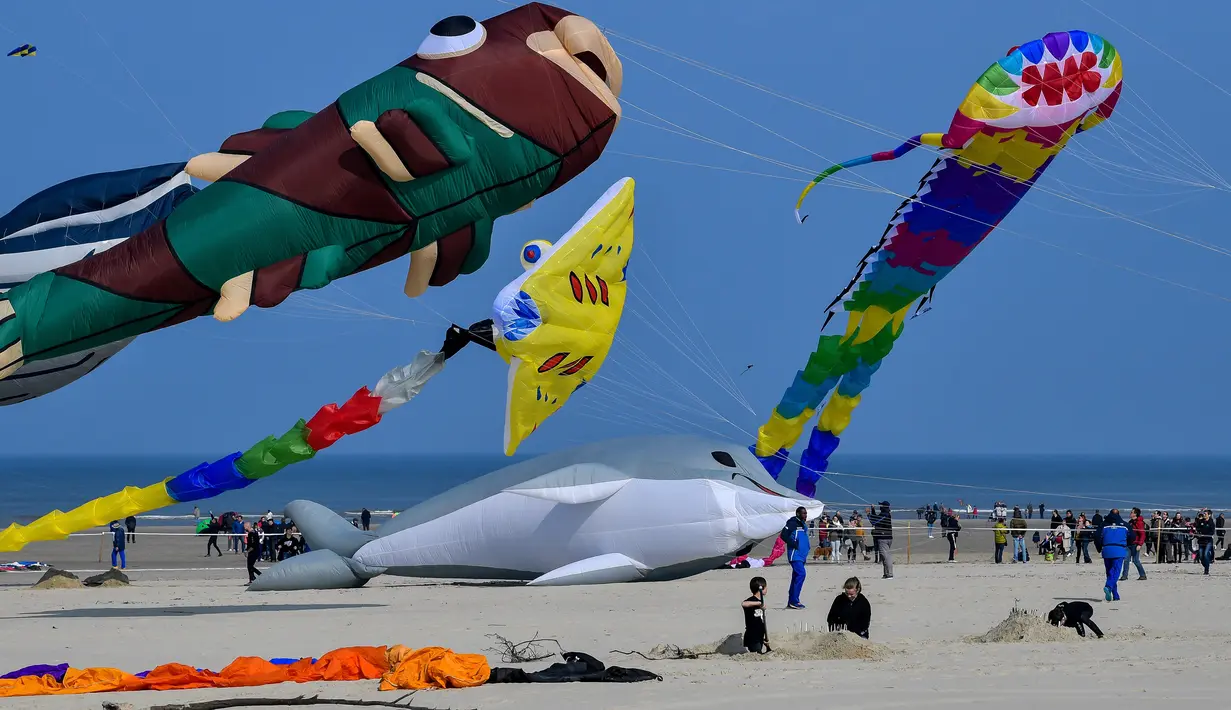 Orang-orang menghadiri Festival Layang-Layang Internasional ke-33 di Berck-sur-Mer, Prancis utara, Sabtu (6/4/2019). Festival Layang-Layang Internasional ini diselenggarakan setiap bulan April dan berlangsung selama 10 hari.  (Photo by Philippe HUGUEN / AFP)