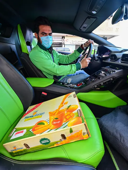 Direktur Pelaksana Pakistan Supermarket Dubai Muhammad Jehanzeb duduk dalam Lamborghini Huracan sebelum mengirim pesanan mangga di Dubai, Uni Emirat Arab, Kamis (2/7/2020). Supermarket tersebut mengantarkan pesanan mangga untuk minimal pesanan sekitar USD 27. (CACACE GIUSEPPE/AFP)
