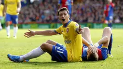 Reaksi Mesut Ozil saat terjatuh di lapangan pada pertandingan Liga Premier Inggris antara Crystal Palace vs Arsenal di Selhurst Park, London (26/10/2013). (AFP/Ian Kington).