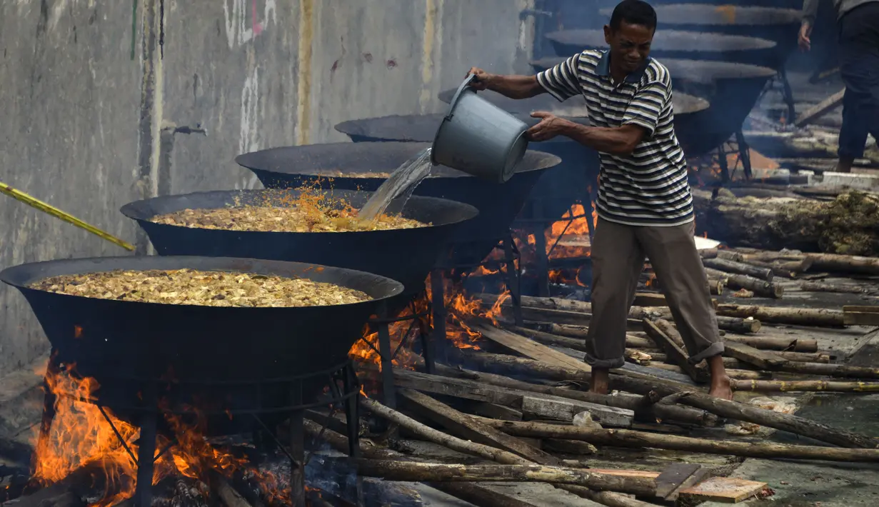 Seorang pria memasak kari tradisional untuk disajikan dalam makanan komunal selama bulan suci Ramadhan di Banda Aceh (25/4/2021). Biasanya, kari tradisional ini juga akan dibagi-bagikan kepada fakir, miskin dan anak yatim. (AFP/Chaideer Mahyuddin)
